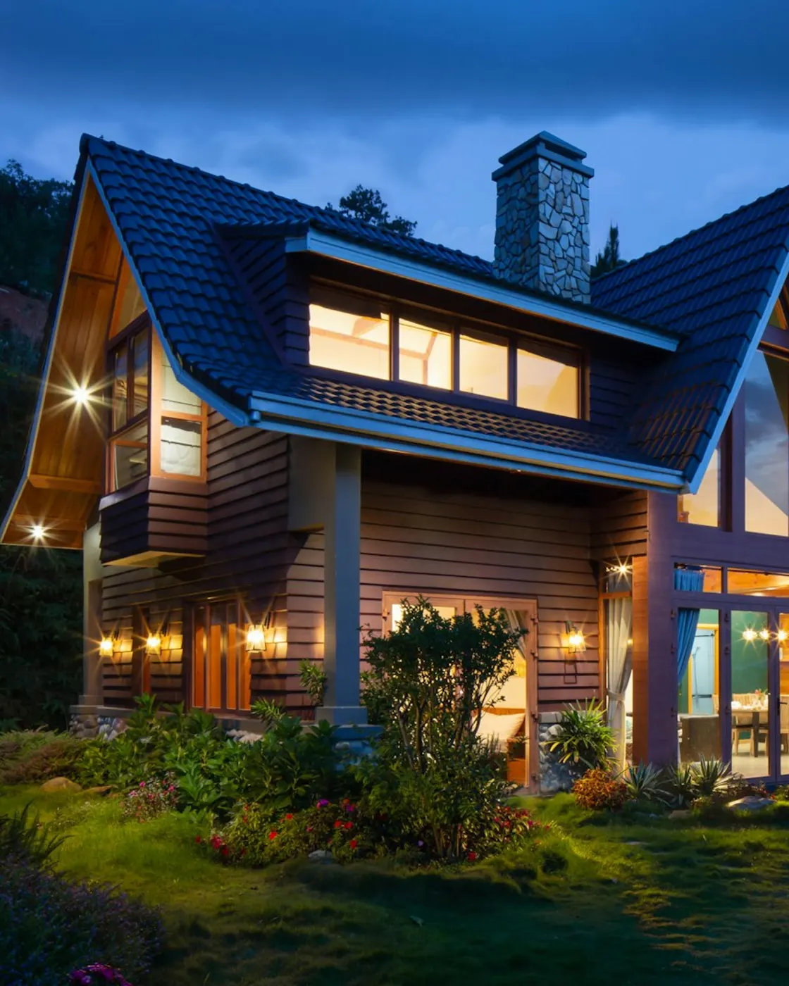 A house at dusk with warm light glowing through its windows